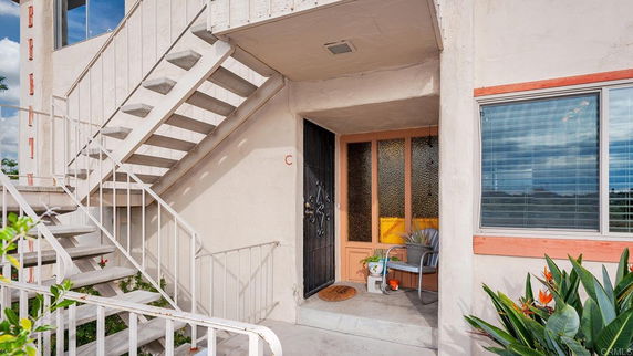 Front view of a small building entrance with stairs and door.