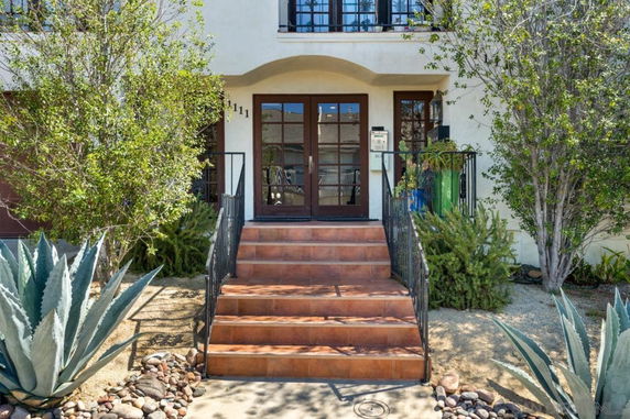Front view of a house with a small staircase leading to a double door entrance.