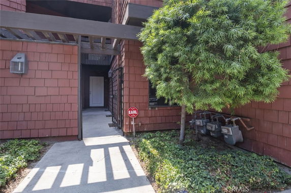 Front view of a building entrance with shingle siding and pathway.