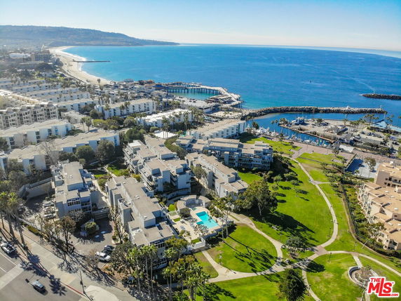 Panoramic view of a coastal area with buildings near the ocean and a marina.