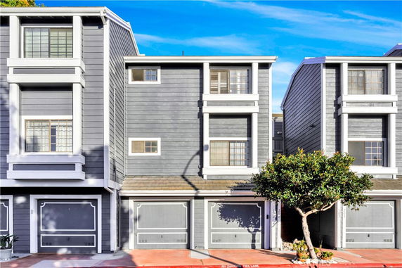 Front view of a multi-story townhouse with a garage.