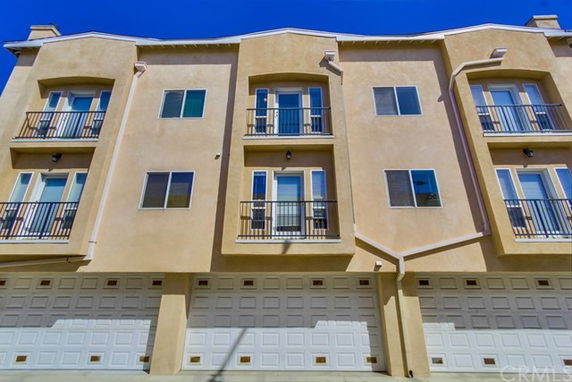 Front view of a multi-story building with garages on the ground floor.