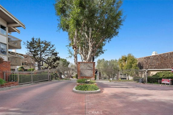 Front view of a gated residential complex entrance with surrounding buildings.