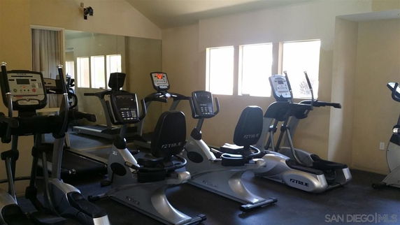Indoor gym area with exercise equipment including treadmills and ellipticals.