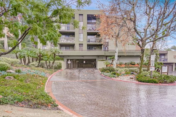 Front view of a multi-story residential building with a covered entrance.