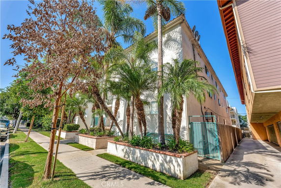 Front view of a multi-story residential building with palm trees