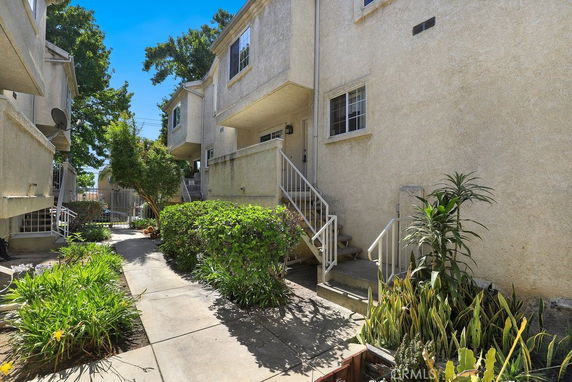 Front view of a two-story townhouse with a small porch and stairs.