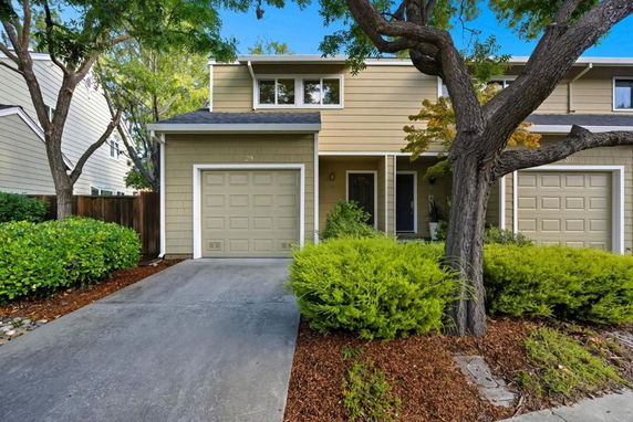 Front view of a two-story house with a single garage and a driveway.