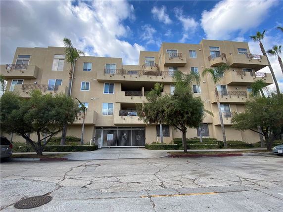 Front view of a multi-story apartment building with balconies.