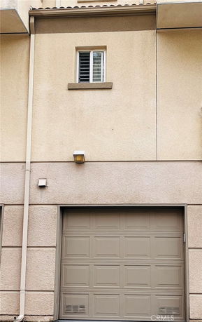 Front view of a building with a garage door and small window above.
