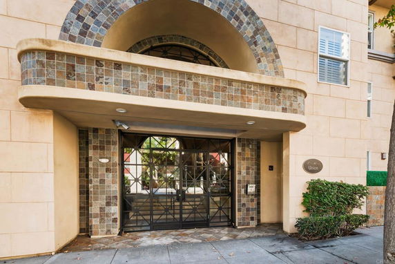 Front view of a building entrance with decorative tile and metalwork.