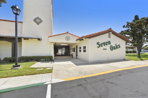 Front view of a building with the sign 'Seven Oaks' and a tall tower structure.