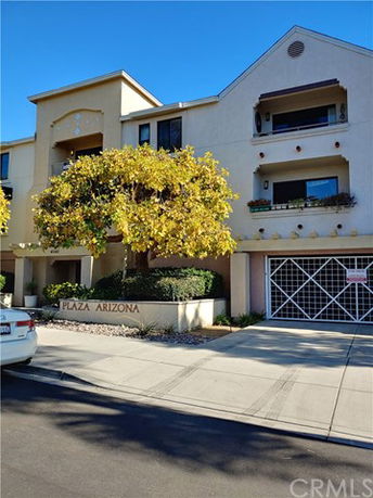 Front view of a multi-story building with balconies and a garage entrance.