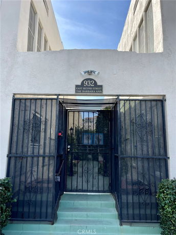 Front view of a building with gated entry and white exterior walls.