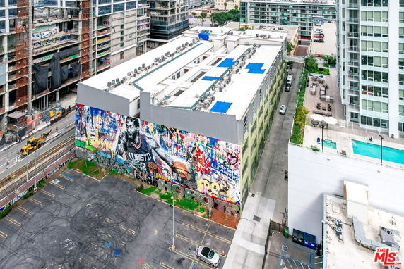 Aerial view of a building with a large mural on its side and rooftop air conditioning units.