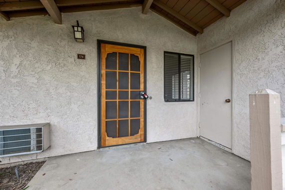 Front view of a building entrance with a wooden door and window.