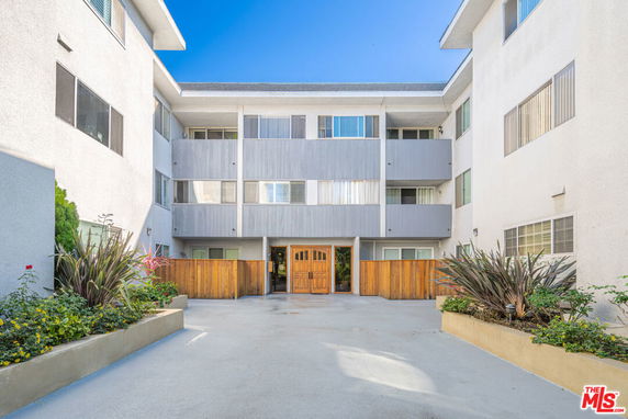 Front view of a multi-story apartment building with a central entrance.
