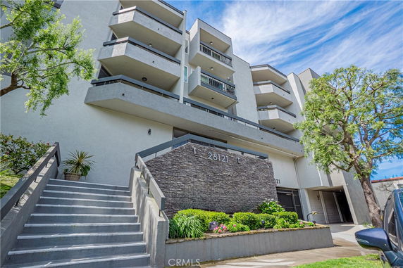 Front view of a multi-story apartment building with balconies.