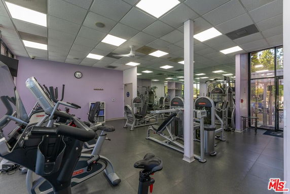 Indoor gym area with exercise equipment and large windows.