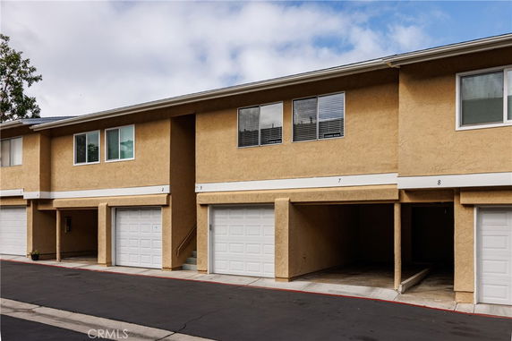 Front view of a two-story building with garages.