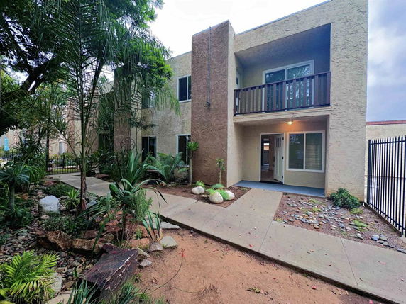 Front view of a two-story building with a balcony and entrance.