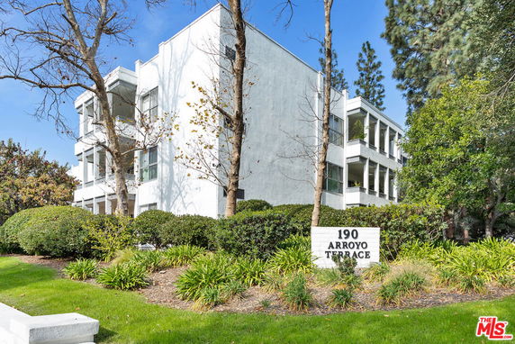 Front view of a white multi-story building with balconies and a sign indicating '190 Arroyo Terrace'.