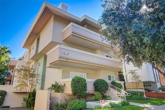 Front view of a multi-story residential building with balconies.