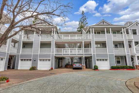 Front view of a multi-story residential building with multiple garages and balconies.