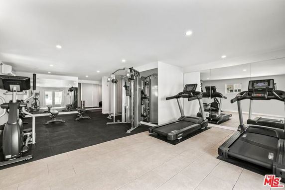 Indoor gym area with various exercise equipment including treadmills and weight machines