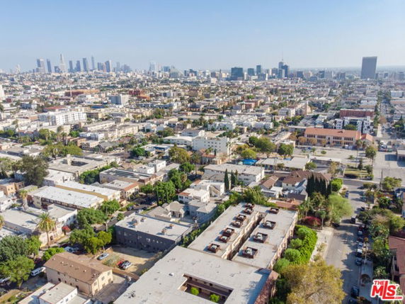 Aerial wide-angle view of a cityscape with numerous buildings and a distant skyline.
