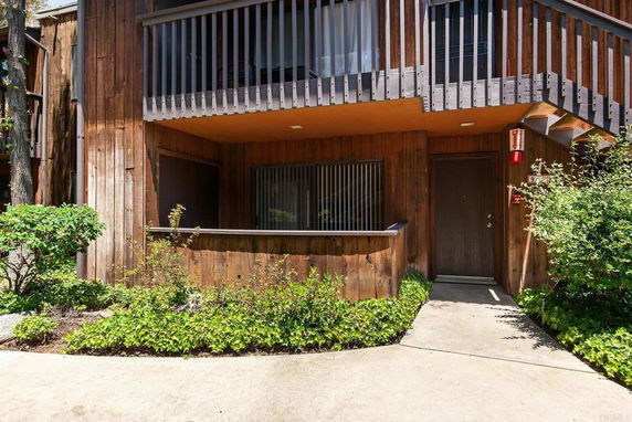 Front view of a two-story wooden building with a balcony and entrance.