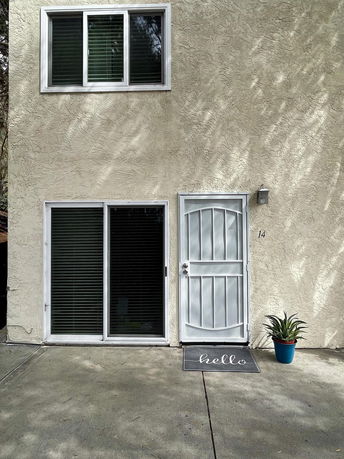 Front view of a house with a door and a window with blinds.