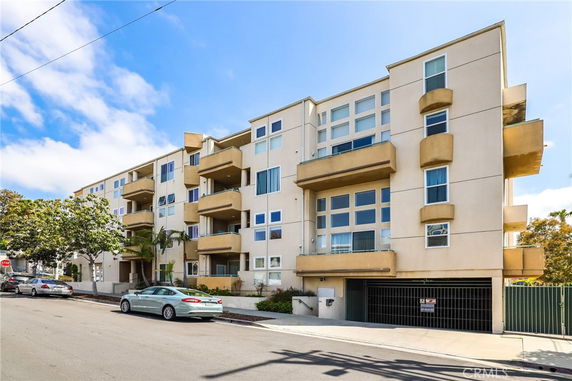 Front view of a multi-story apartment building with balconies.