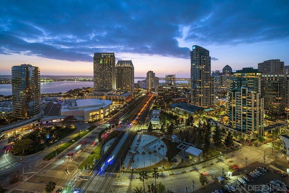 Panoramic view of a cityscape at dusk with tall buildings and streets.