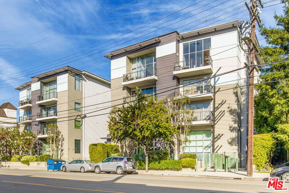 Front view of a modern multi-story apartment building with balconies.