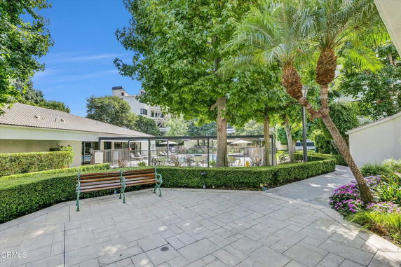 Outdoor area with a pool surrounded by trees and seating.