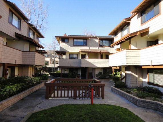 Front view of a multi-story residential building with balconies and large windows.