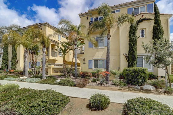Front view of a multi-story residential building with palm trees.