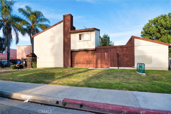 Front view of a two-story house with a unique angular roof design and wooden paneling.