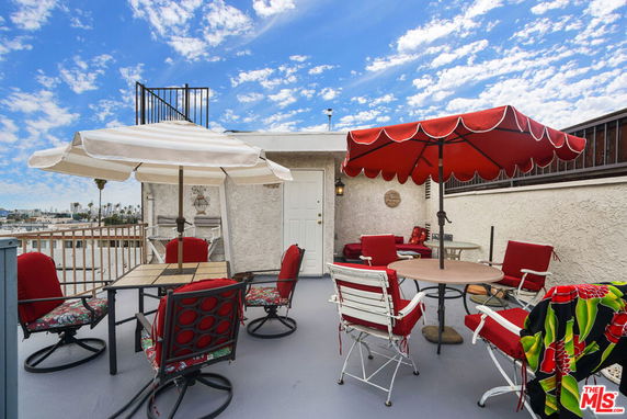 Rooftop view with seating and umbrellas on a sunny day.