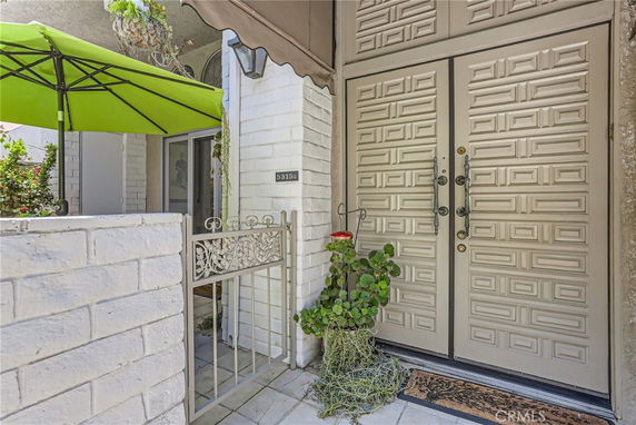 Front entrance of a house with patterned doors and a small gated area.