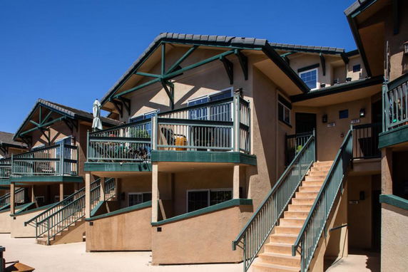 Front view of a two-story apartment building with balconies and staircases.