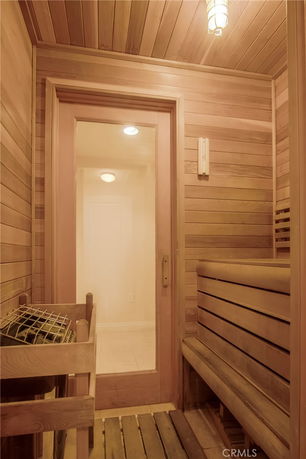 Interior view of a sauna room with wooden benches and a door.