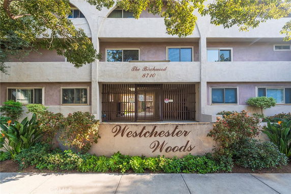 Front view of a multi-story residential building named Westchester Woods.