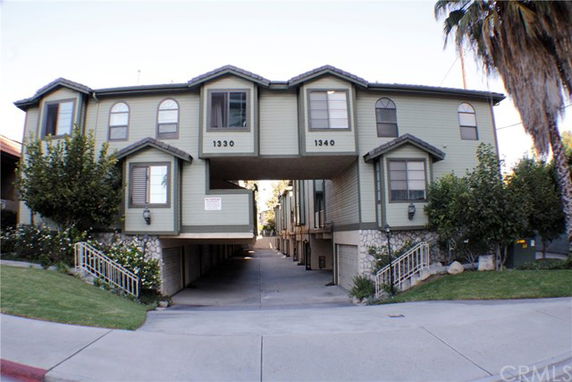Front view of a two-story apartment building with an integrated carport.