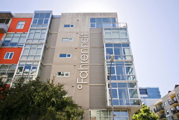Front view of a modern multi-story building with large glass windows.