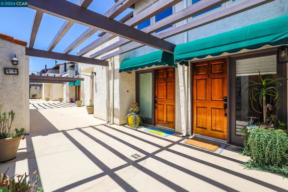 Front view of a building with wooden doors and green awnings.