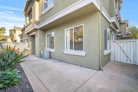 Front view of a two-story house with a small garden and concrete pathway.