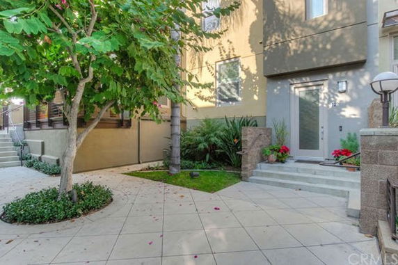 Front view of a modern multi-story house with steps leading to the entrance.