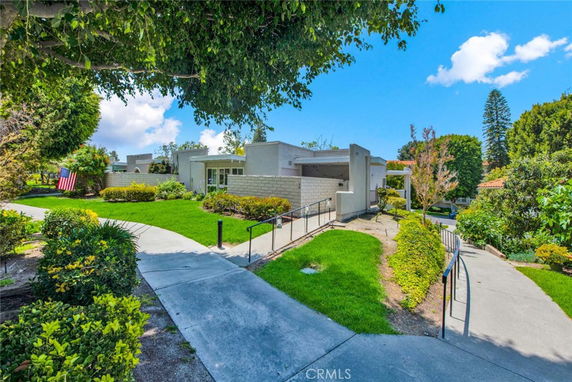 Front view of a modern single-story house with a flat roof and landscaped garden.